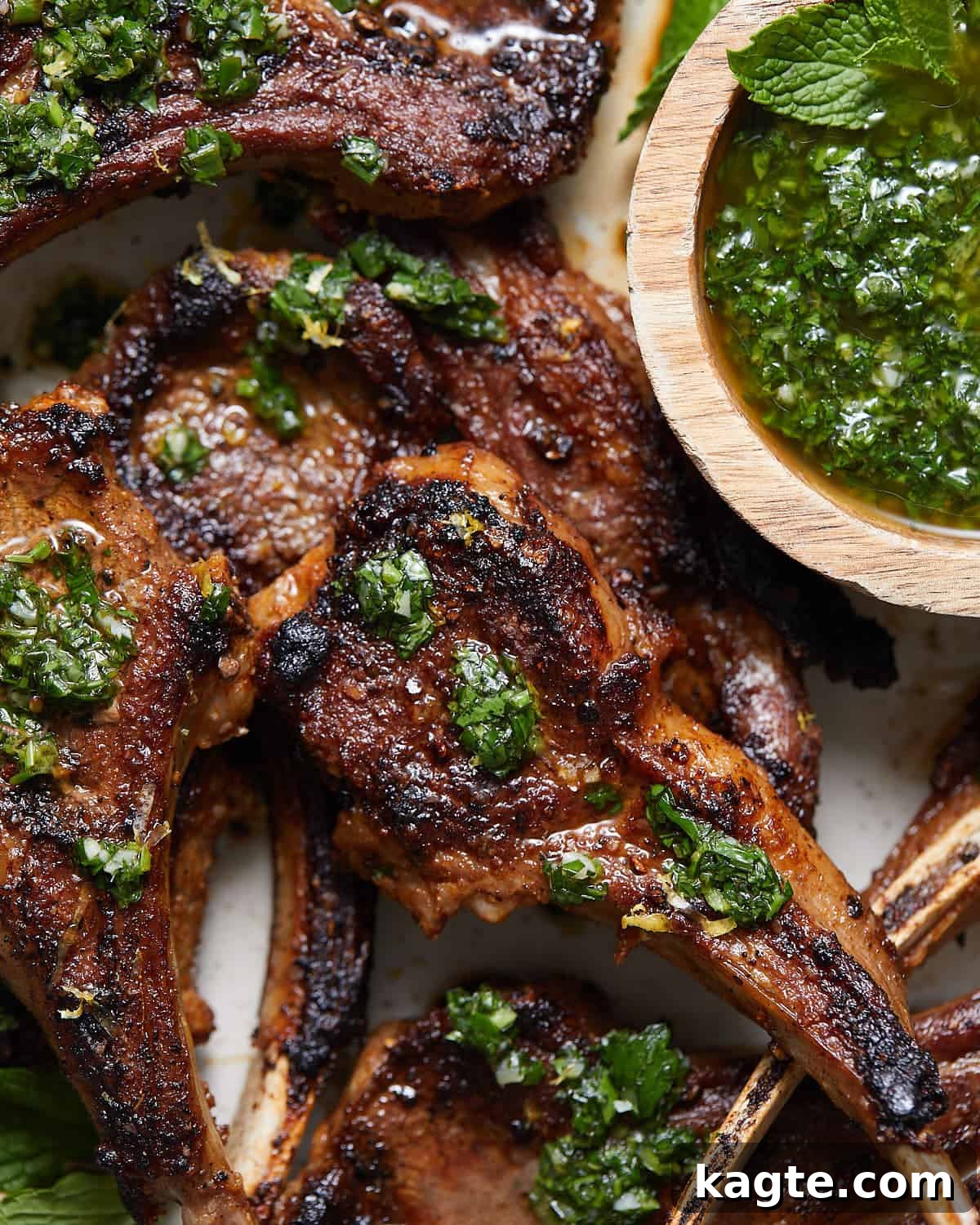 Sizzling Cast Iron Lamb Chops 5 Up close image of lamb chops on serving dish with garnish.