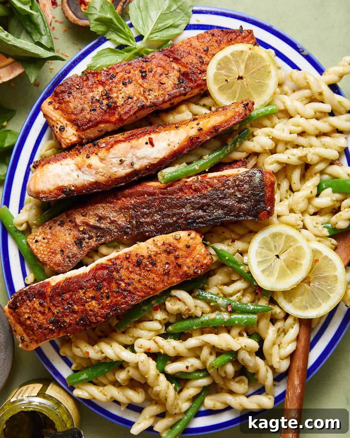 A vibrant bowl of salmon pasta without cream, featuring flaky salmon fillets, green beans, and a lemon-pesto sauce, ready to be served.