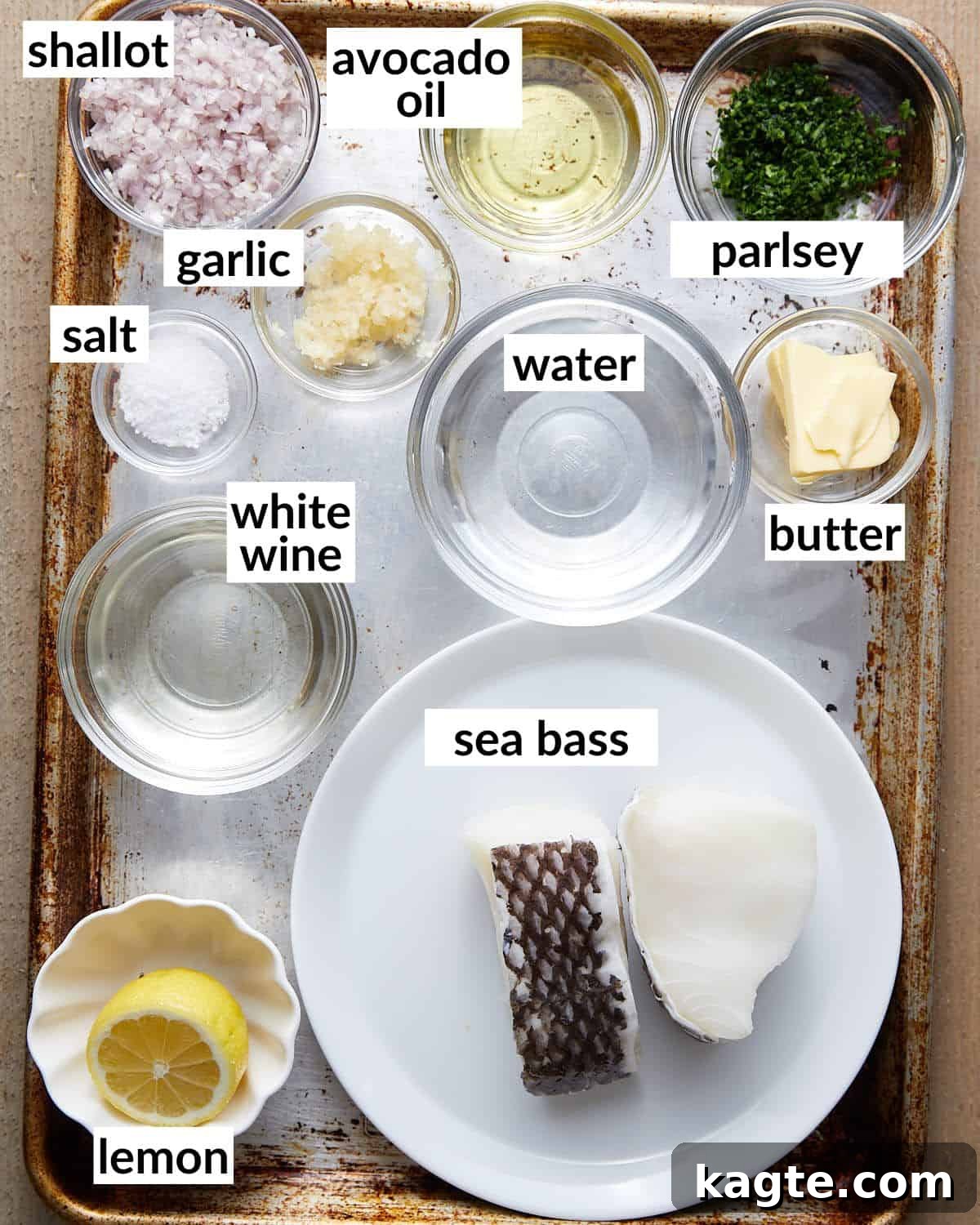 Overhead image of fresh ingredients for pan seared chilean sea bass, including fillets, lemon, herbs, and spices.