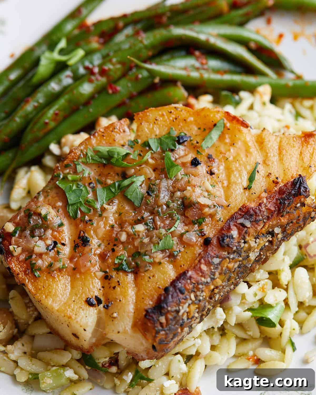 Up close image of golden-brown pan seared chilean sea bass fillet with sauce.