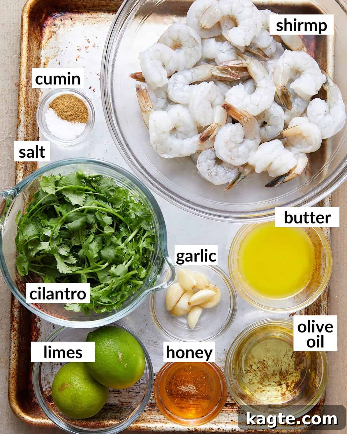 Juicy Oven Baked Shrimp Skewers 3 Overhead image of ingredients needed for oven baked shrimp skewers, including fresh cilantro, limes, garlic, honey, and raw shrimp.