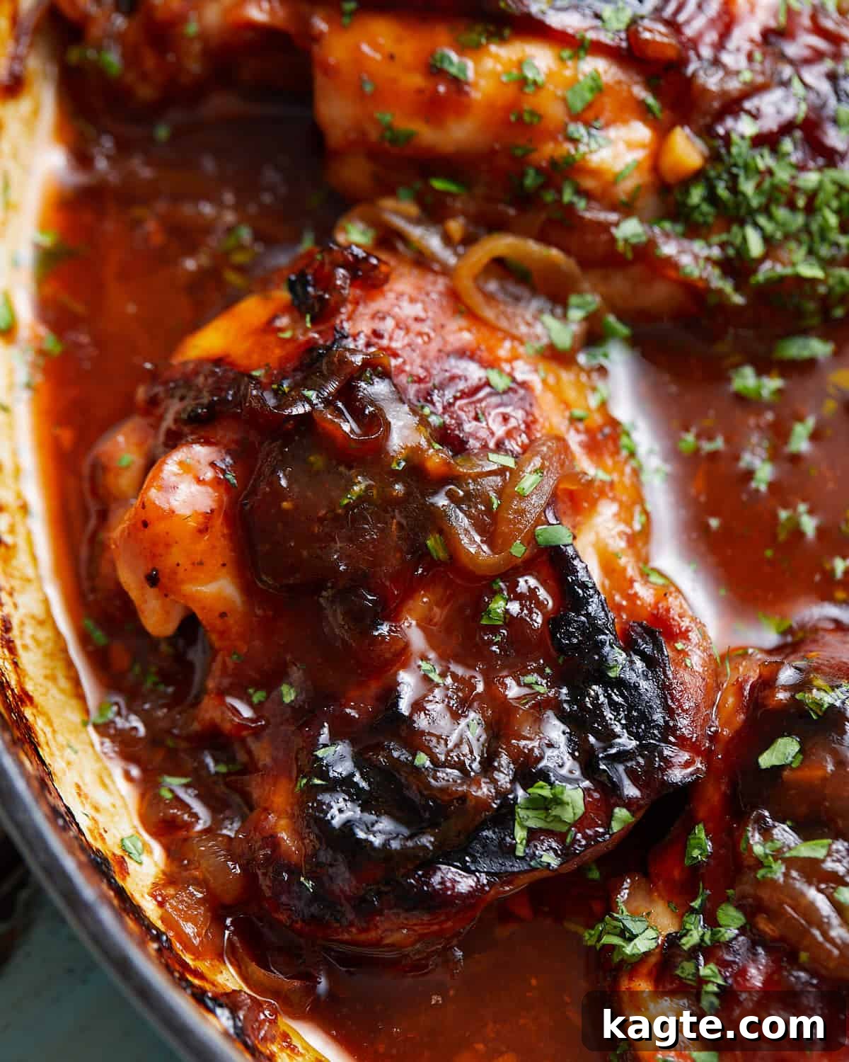 An up-close image of Dutch oven BBQ chicken, showing the crispy skin and sticky sauce.