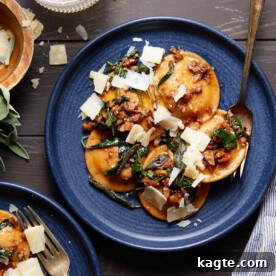 A bowl of rich butternut squash ravioli sauce, garnished with fresh sage and pecans.