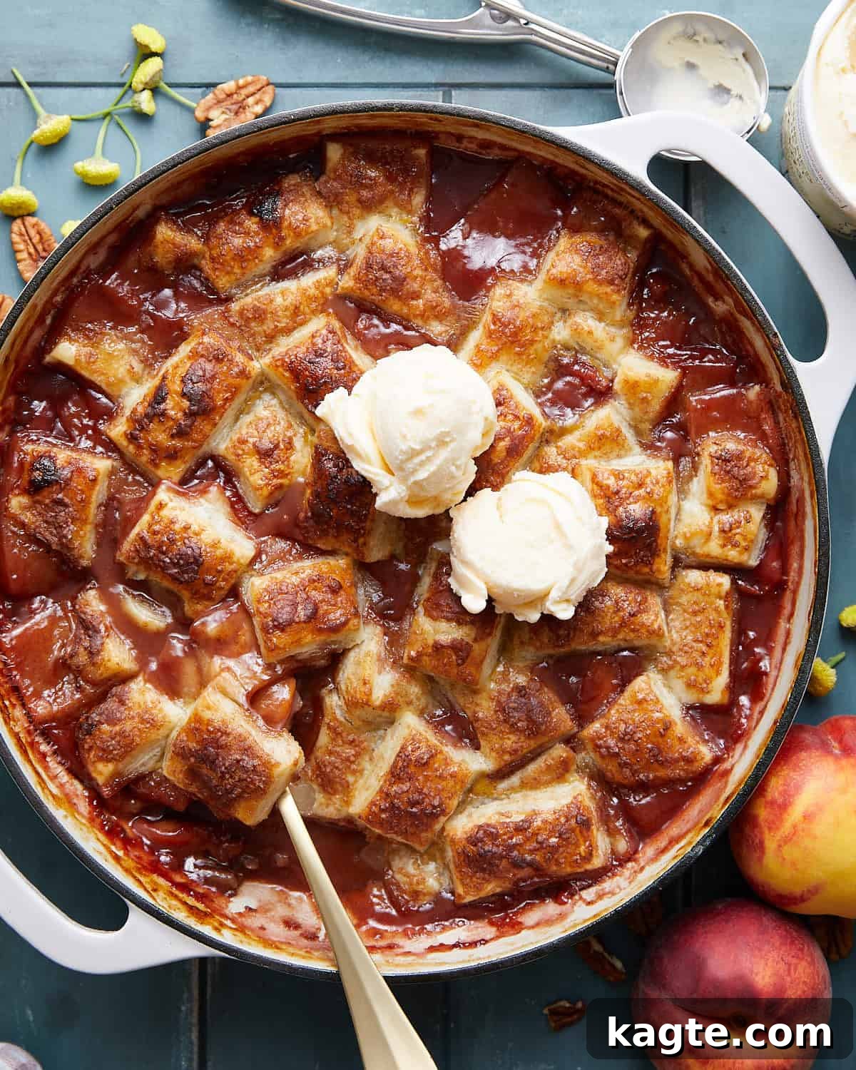 Golden Flaky Peach Cobbler 2 Golden brown peach cobbler with a flaky puff pastry topping, served in a skillet with a scoop of vanilla ice cream melting on top.