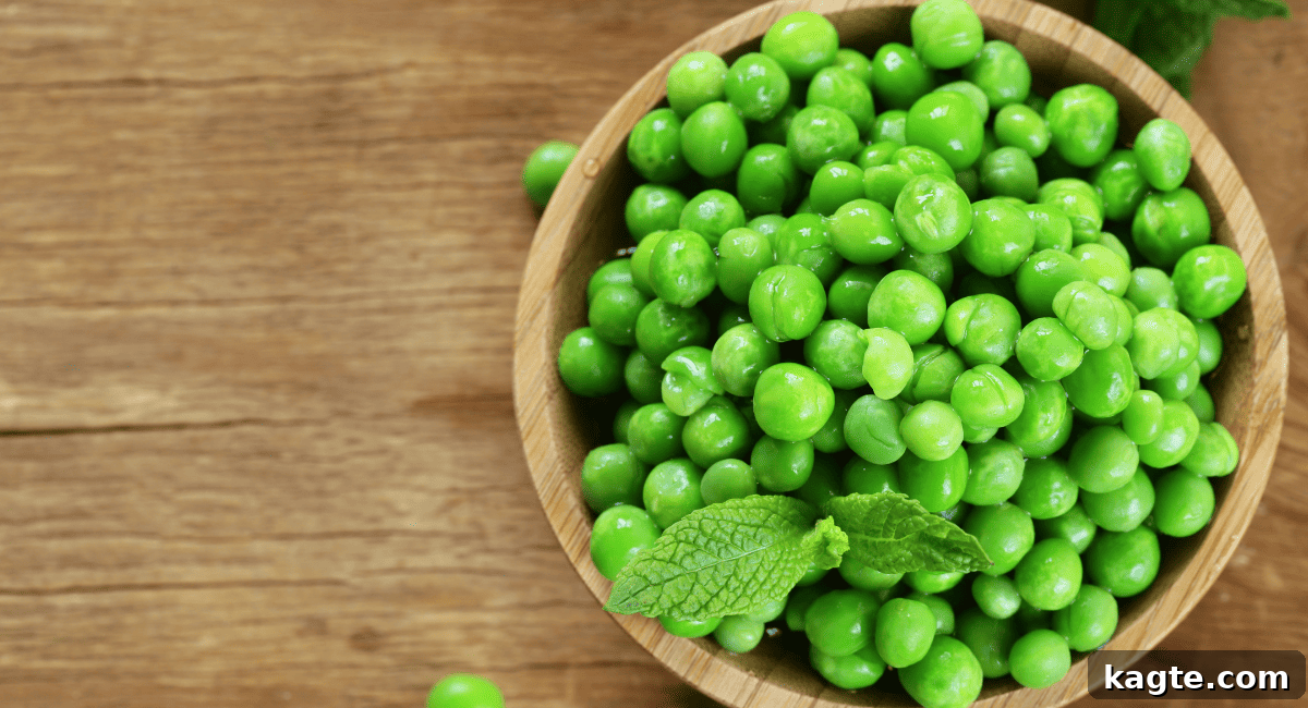 Overhead image of green peas scattered on a surface.