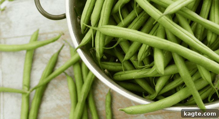 A pile of fresh, vibrant green beans, some scattered loose.