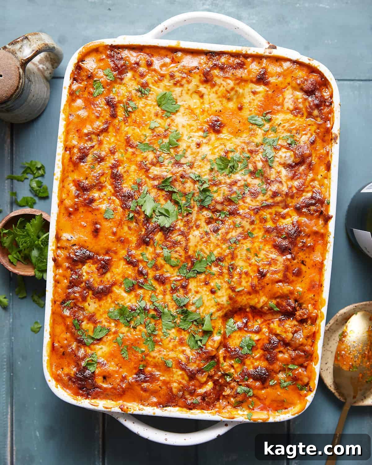Overhead image of cheesy baked spaghetti with garnish.