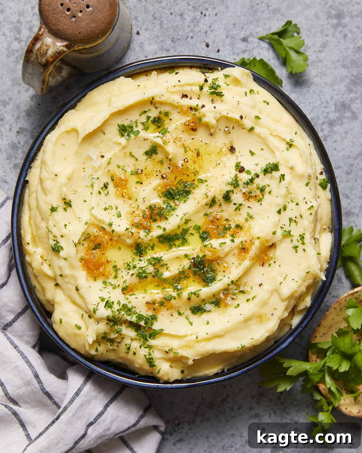 Velvety Yukon Gold Mash 2 Overhead image of a bowl of creamy Yukon Gold mashed potatoes, garnished with fresh herbs.