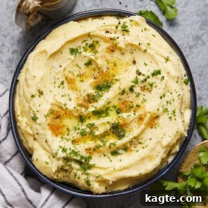 A bowl of creamy Yukon Gold mashed potatoes, garnished with fresh herbs, ready to serve.