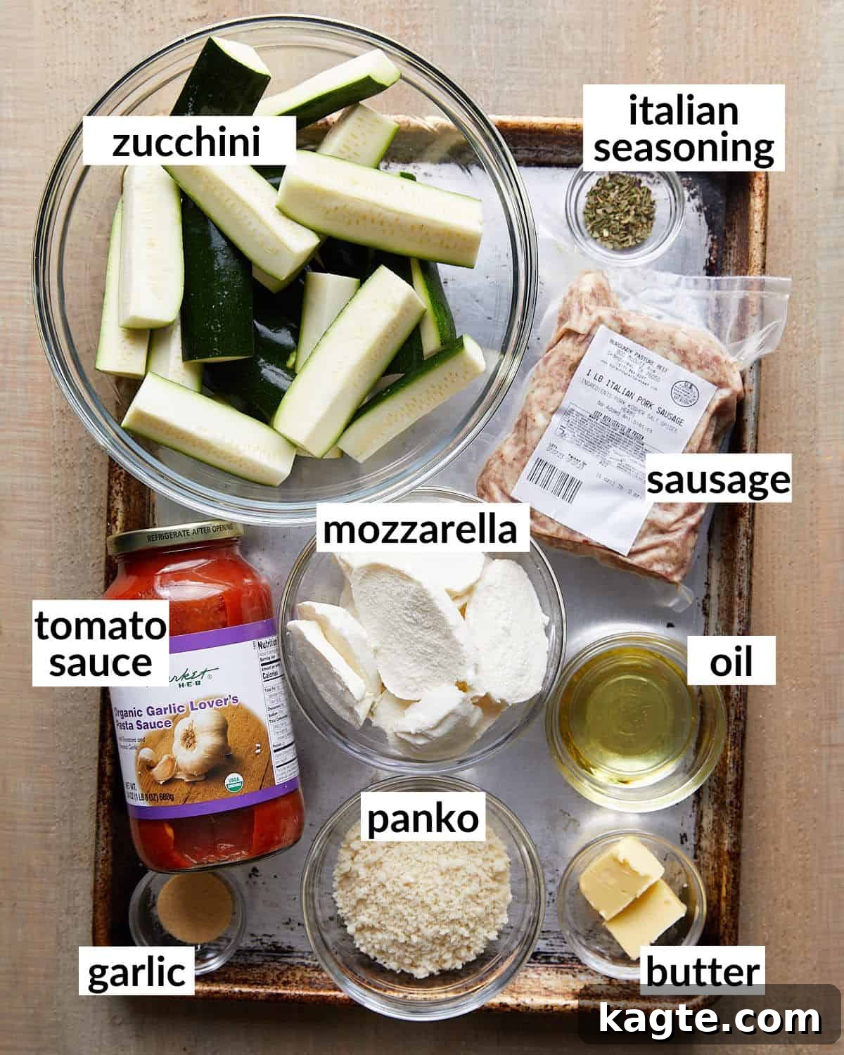 Overhead image displaying all the fresh ingredients needed to prepare Italian baked zucchini: zucchini slices, ground Italian sausage, pasta sauce, mozzarella cheese, and spices.