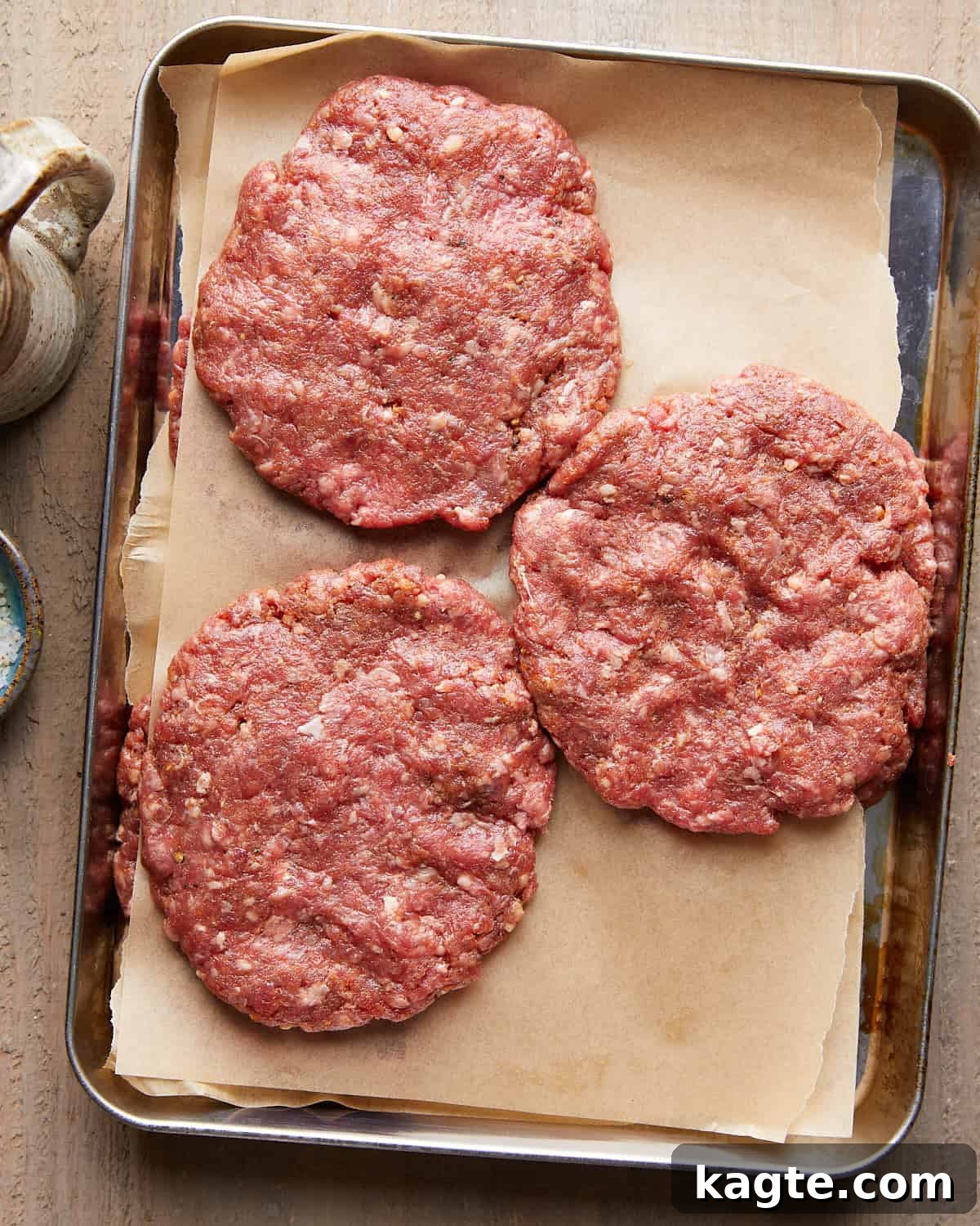 Overhead image of raw hamburger patties.