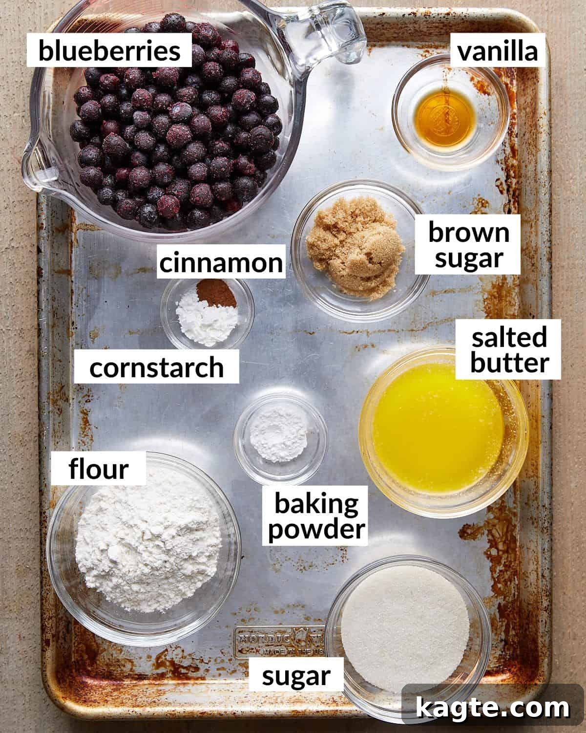 Effortless Air Fryer Blueberry Cobbler 3 Overhead image showing all the ingredients needed to make air fryer blueberry cobbler laid out on a surface.