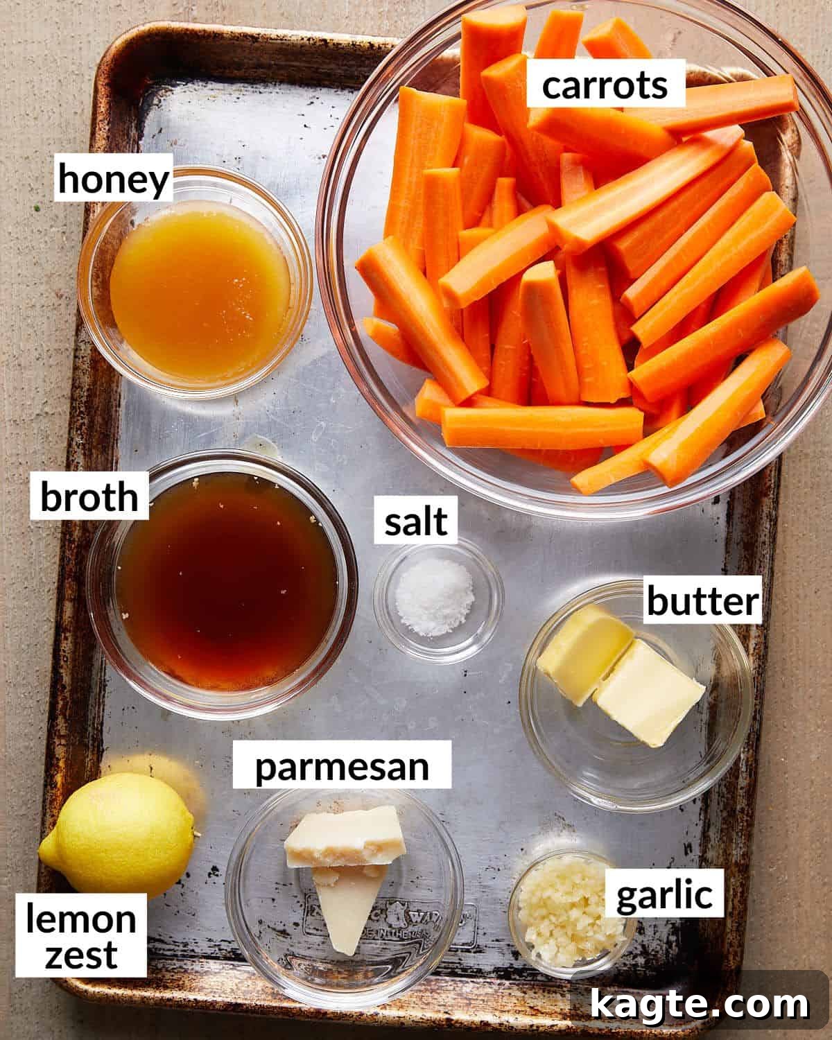 All the fresh ingredients laid out for making stovetop glazed carrots, including carrots, butter, honey, garlic, and lemon.