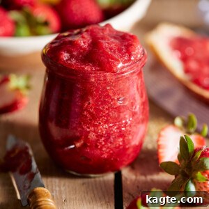 Homemade Strawberry Preserves in a jar with a spoon.