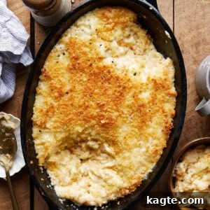 A close-up image of a perfectly baked white cheddar mac and cheese, showing its crispy topping.