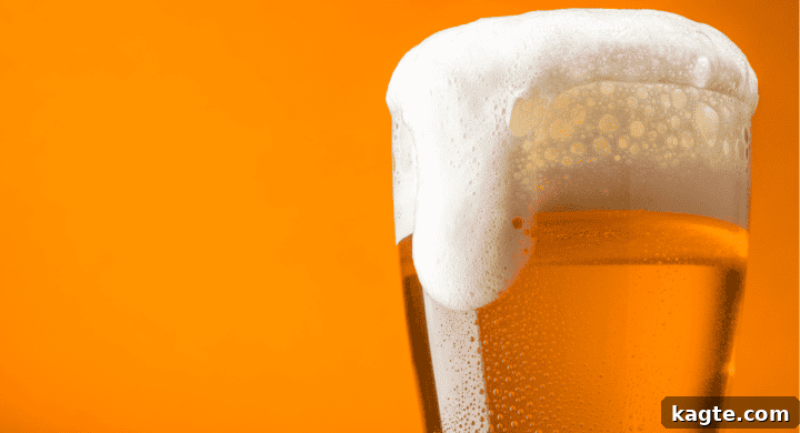 A glass of amber beer on a wooden table.