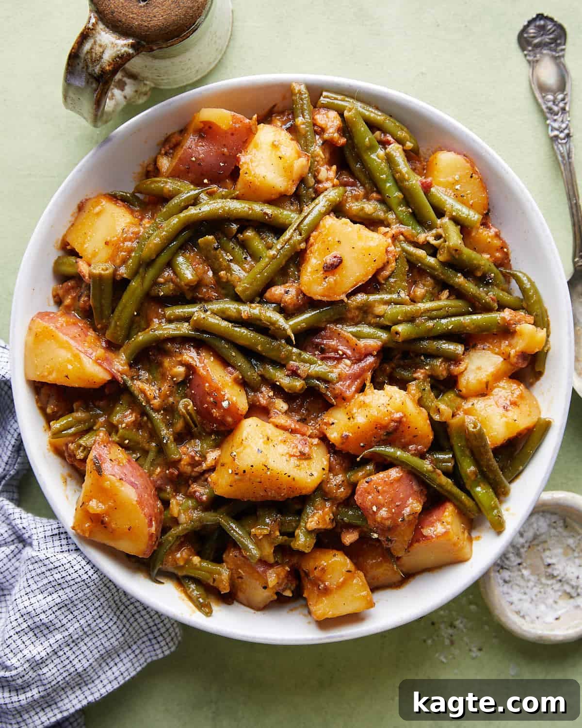 Down-Home Southern Green Beans and Potatoes 2 Overhead image of a generous serving of green beans and potatoes with bacon, garnished with fresh herbs, ready to be enjoyed.