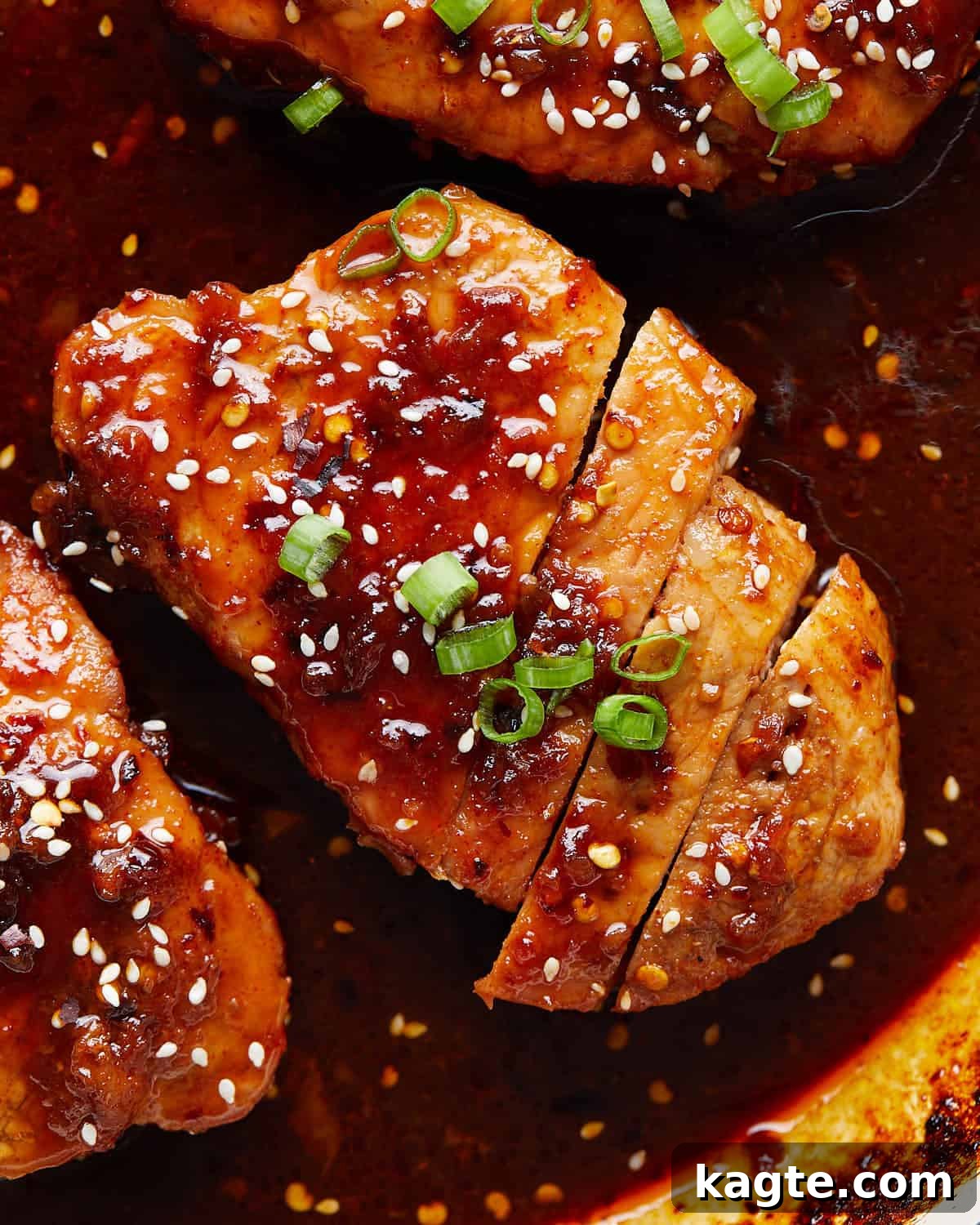 Sticky Brown Sugar Garlic Pork Chops 5 Up close image of brown sugar garlic pork chop with garnish.