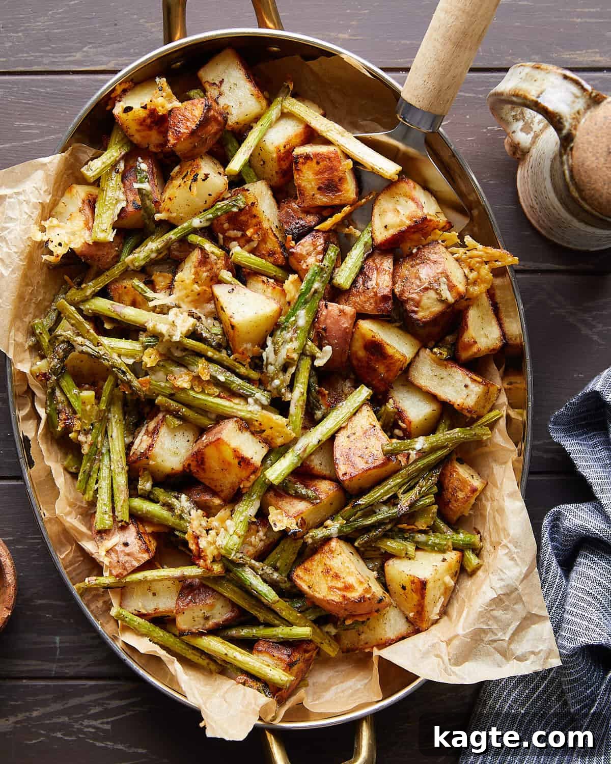 Overhead image of roasted potatoes and asparagus with garnish, ready to be served.