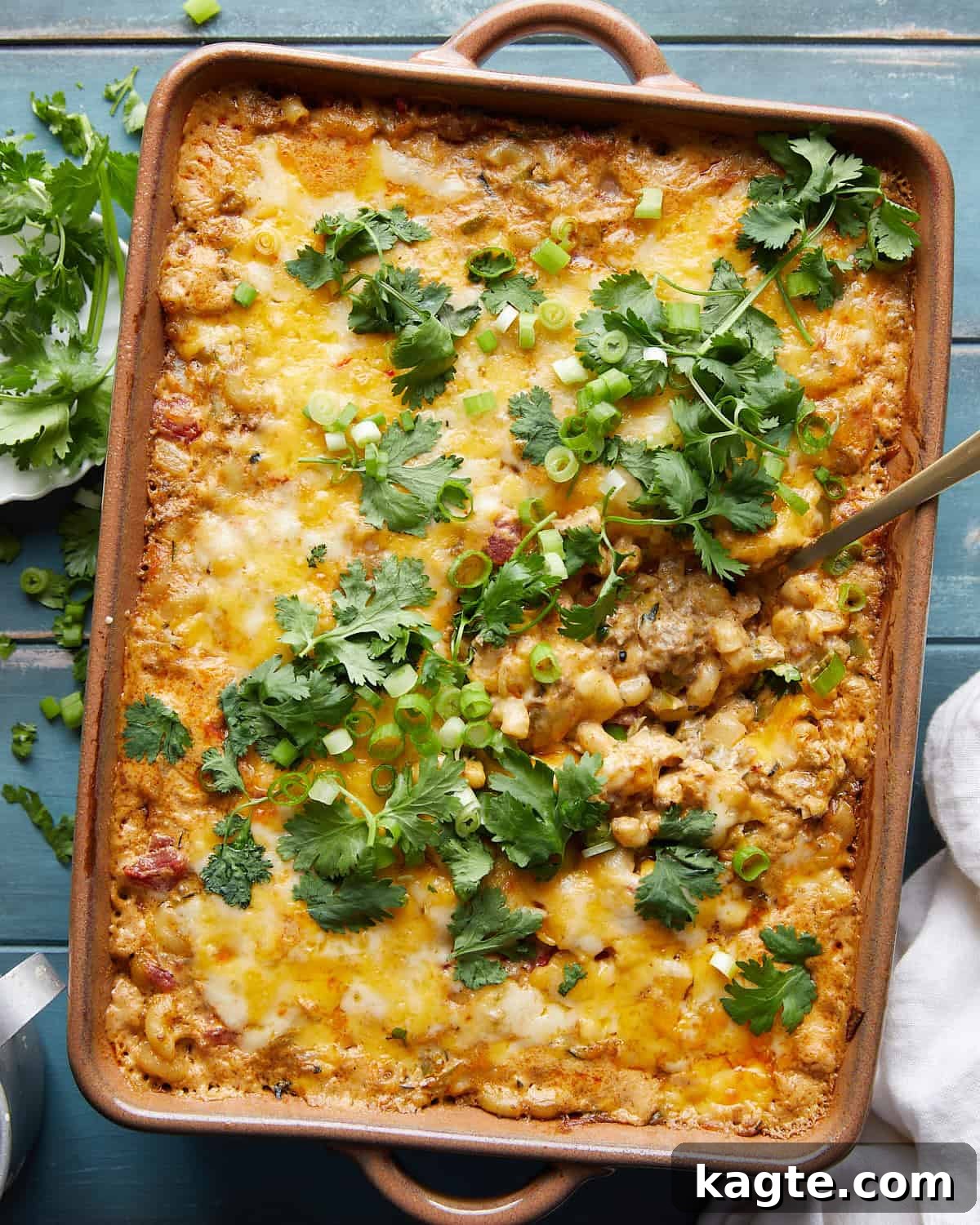 Fiesta Cheesy Taco Pasta Bake 2 Overhead image of a bubbling, golden brown taco pasta bake in a casserole dish, garnished with fresh cilantro.