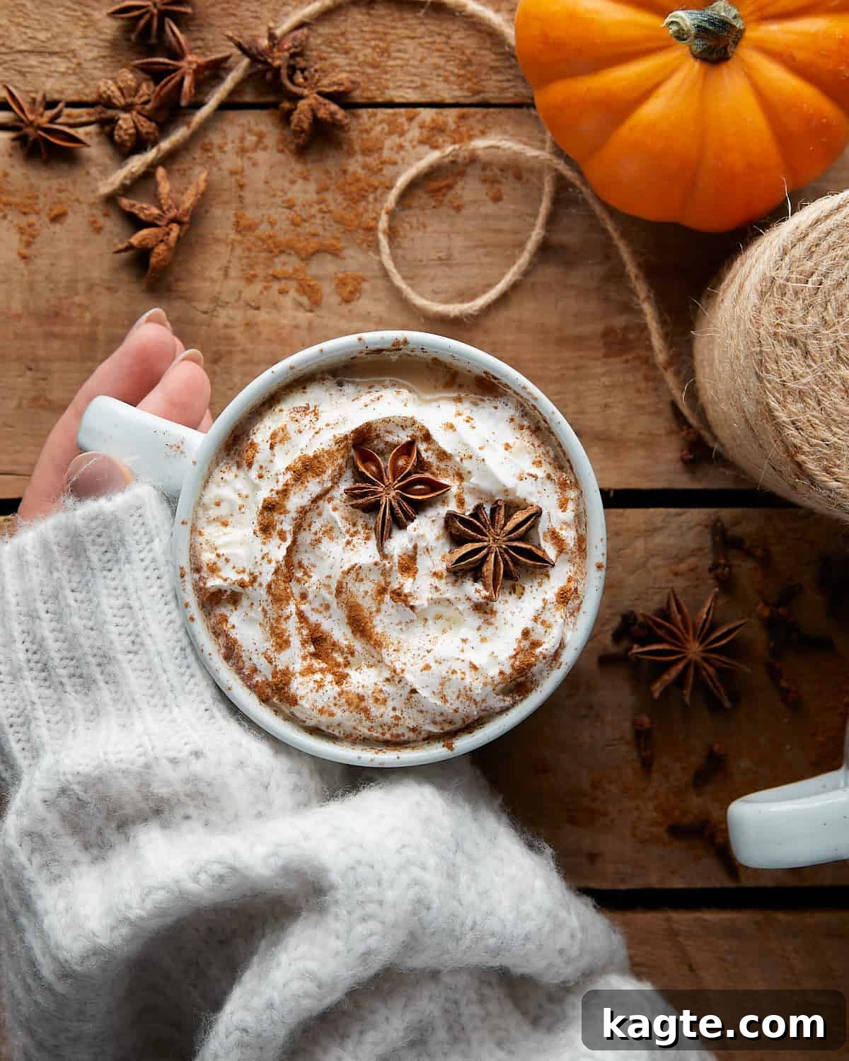 Effortless Pumpkin Spice Chai Latte 2 Overhead image of a beautifully frothed pumpkin spice chai latte in a clear glass mug, garnished with a sprinkle of cinnamon.
