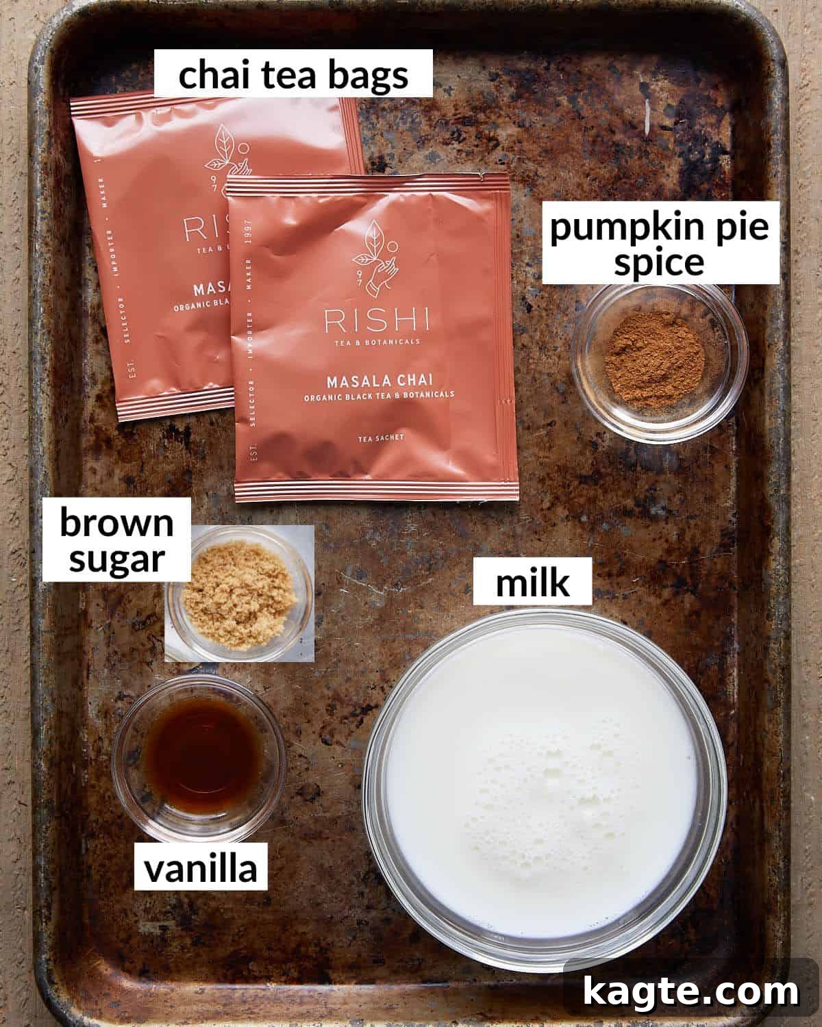 Effortless Pumpkin Spice Chai Latte 3 An overhead image showing the individual ingredients laid out neatly: chai tea bags, a glass of milk, a small bowl of brown sugar, a bowl of pumpkin pie spice, and a bottle of vanilla extract.