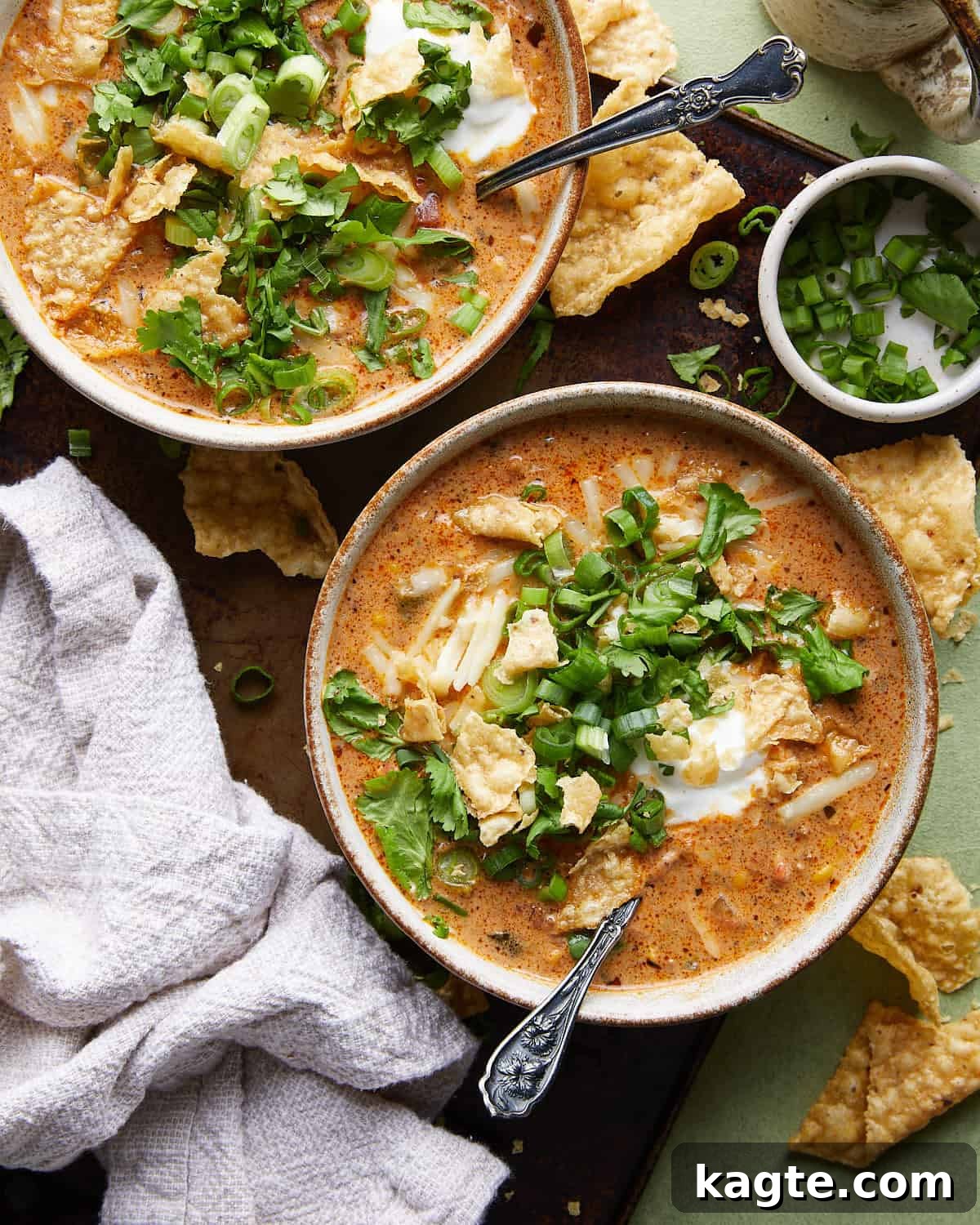 Easy Creamy Beef Enchilada Soup Stovetop and Slow Cooker 2 Overhead image of beef enchilada soup with toppings including shredded cheese, sour cream, and fresh cilantro.