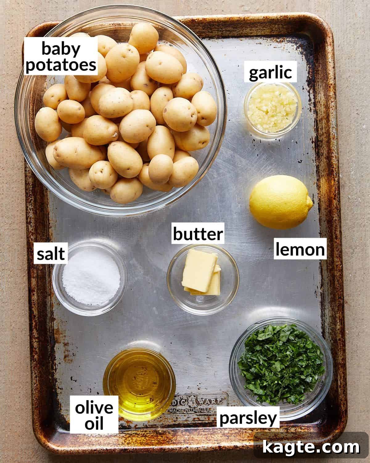 Overhead image of ingredients needed for garlic parsley potatoes laid out on a surface.