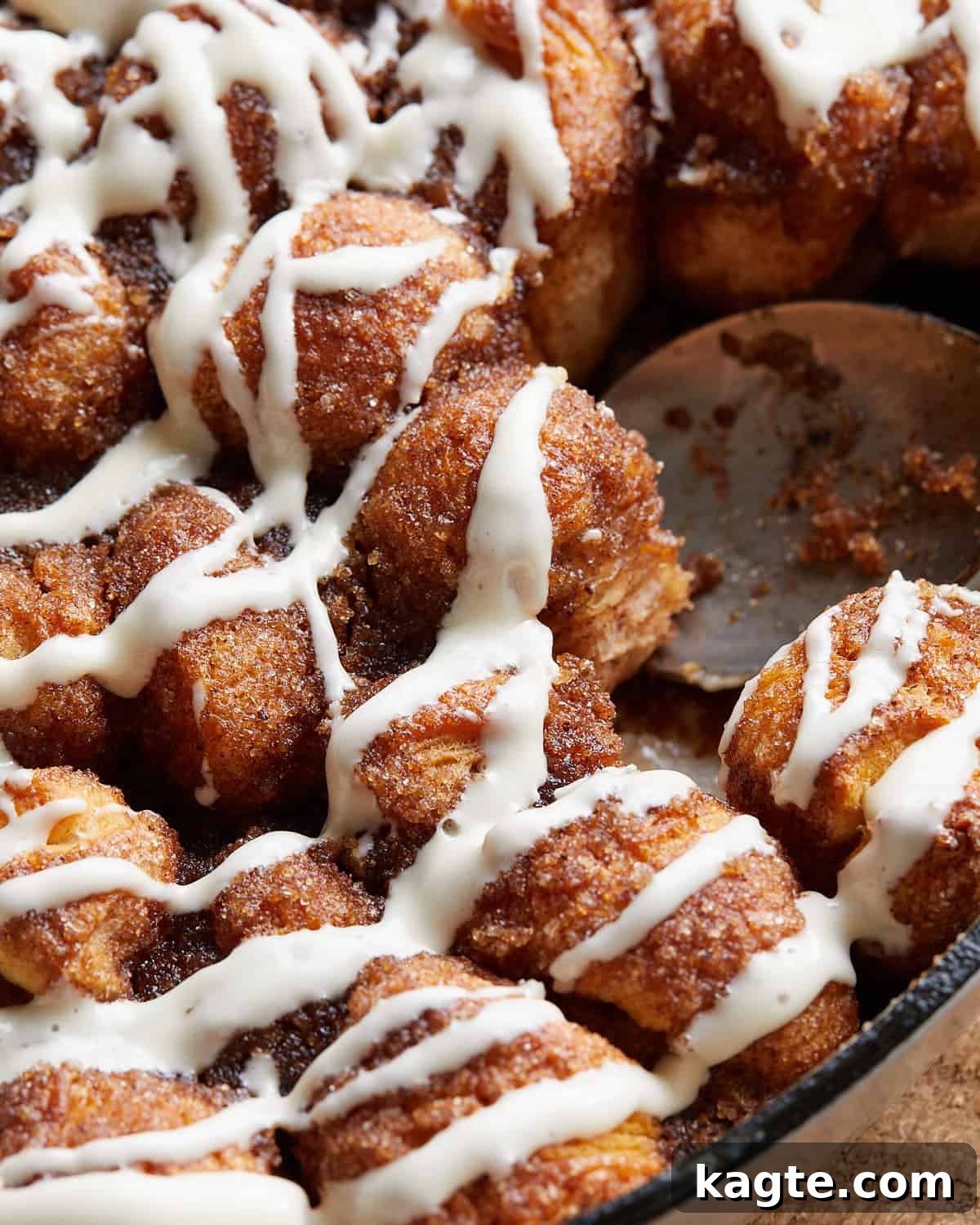 Up close image of Dutch oven monkey bread with a creamy glaze, showing its soft, pull-apart texture.