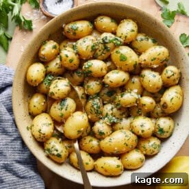 Close-up of boiled garlic parsley potatoes, showing the buttery and herby coating.