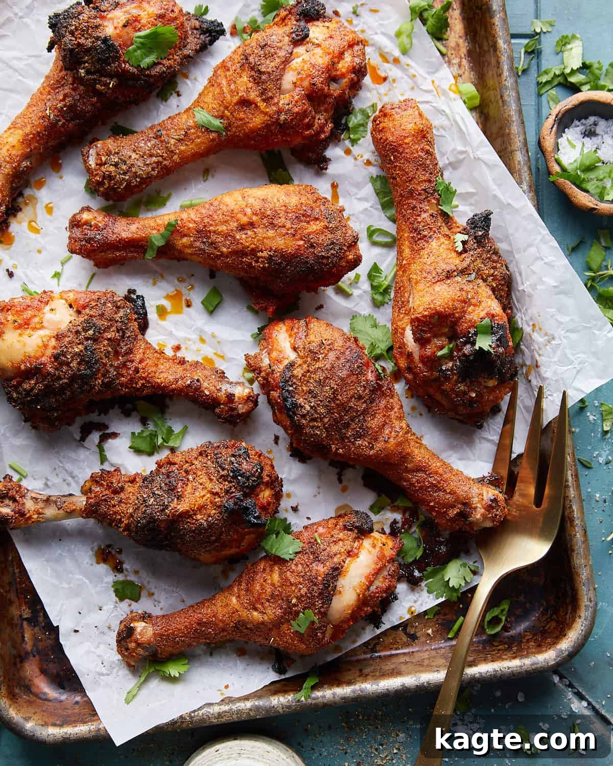Overhead image of crispy baked chicken legs garnished with fresh herbs, ready to serve.