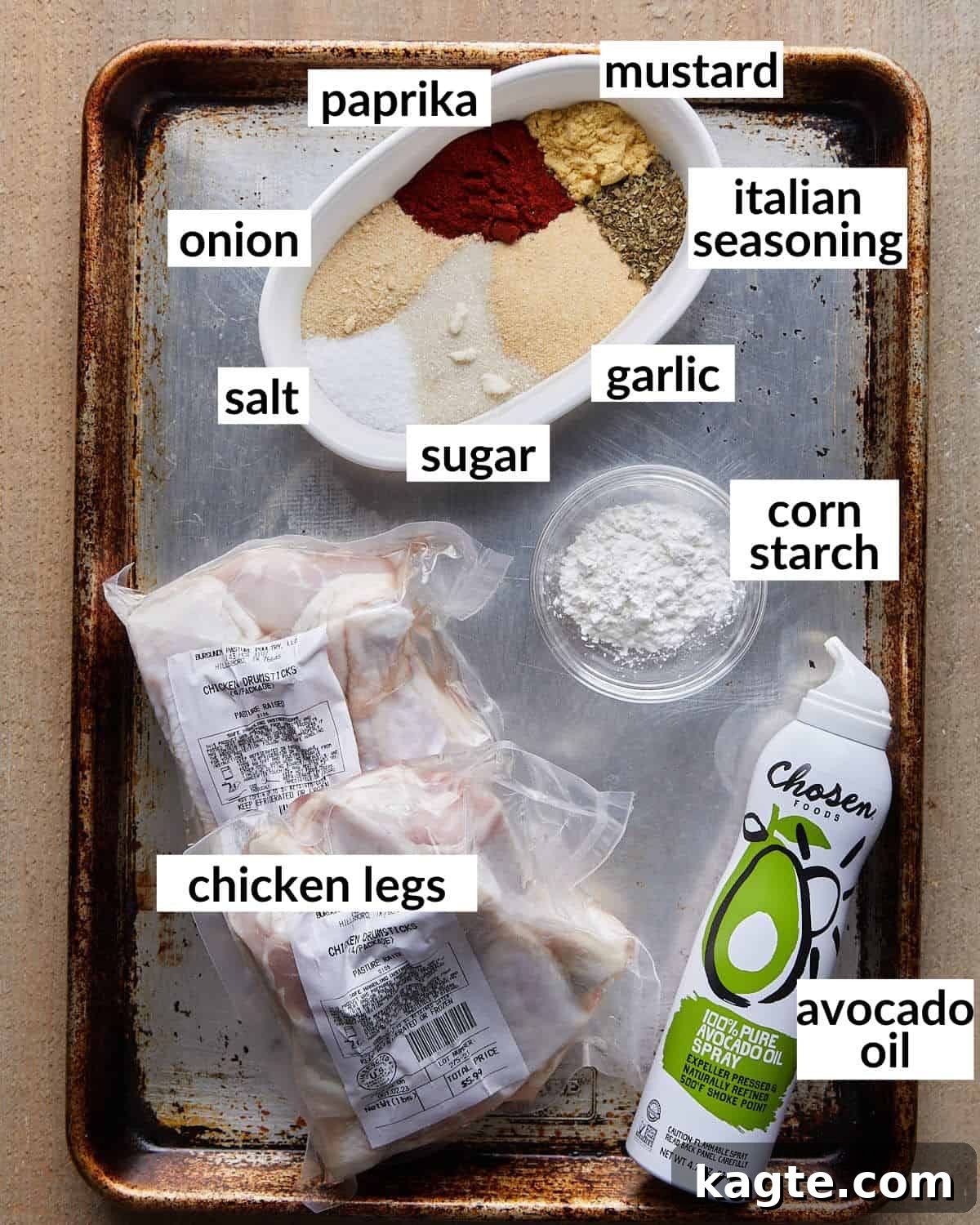 Overhead image displaying all the individual ingredients laid out for making baked chicken legs, including drumsticks, spices, and oil.