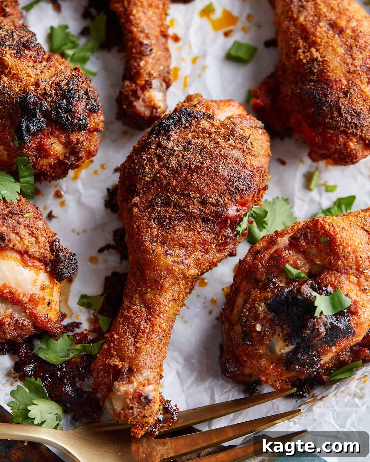 Up close image of the perfectly crispy and golden-brown skin on a baked chicken leg, garnished with fresh parsley.