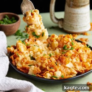 Finished Crockpot Funeral Potatoes with a scoop taken out, revealing the creamy interior and crispy topping.