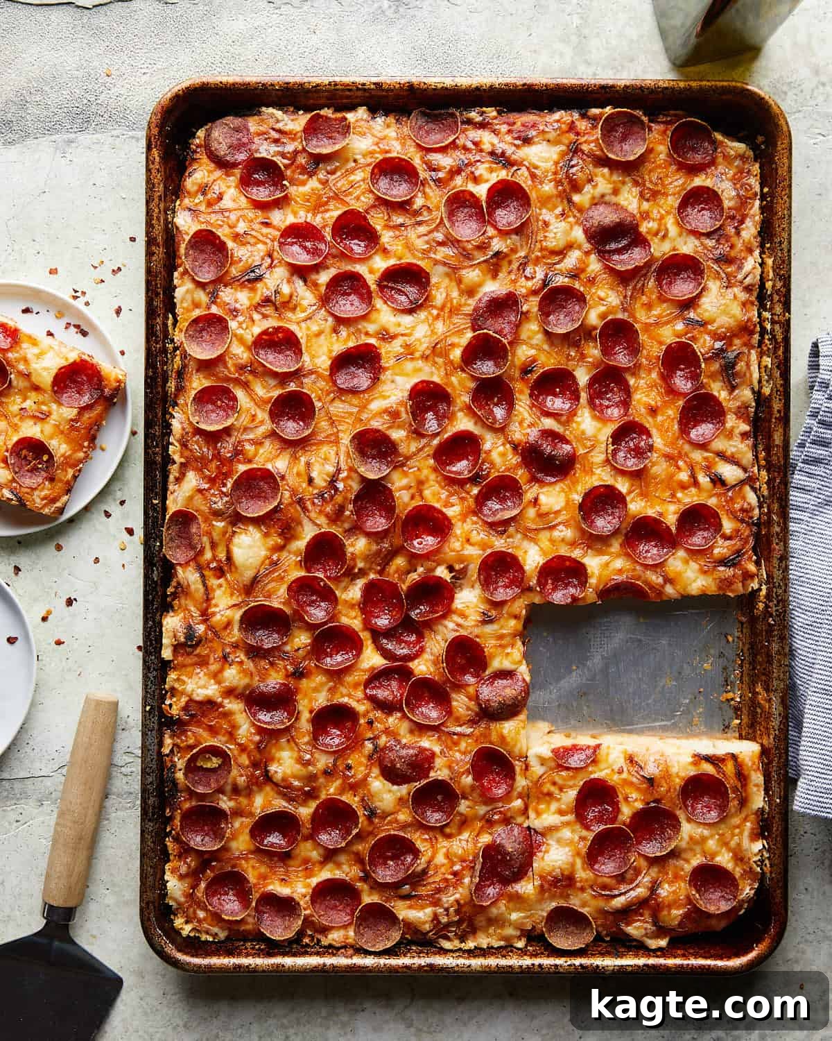 Overhead image of crispy pepperoni sheet pan pizza, showcasing its golden crust, melted cheese, and abundant pepperoni.