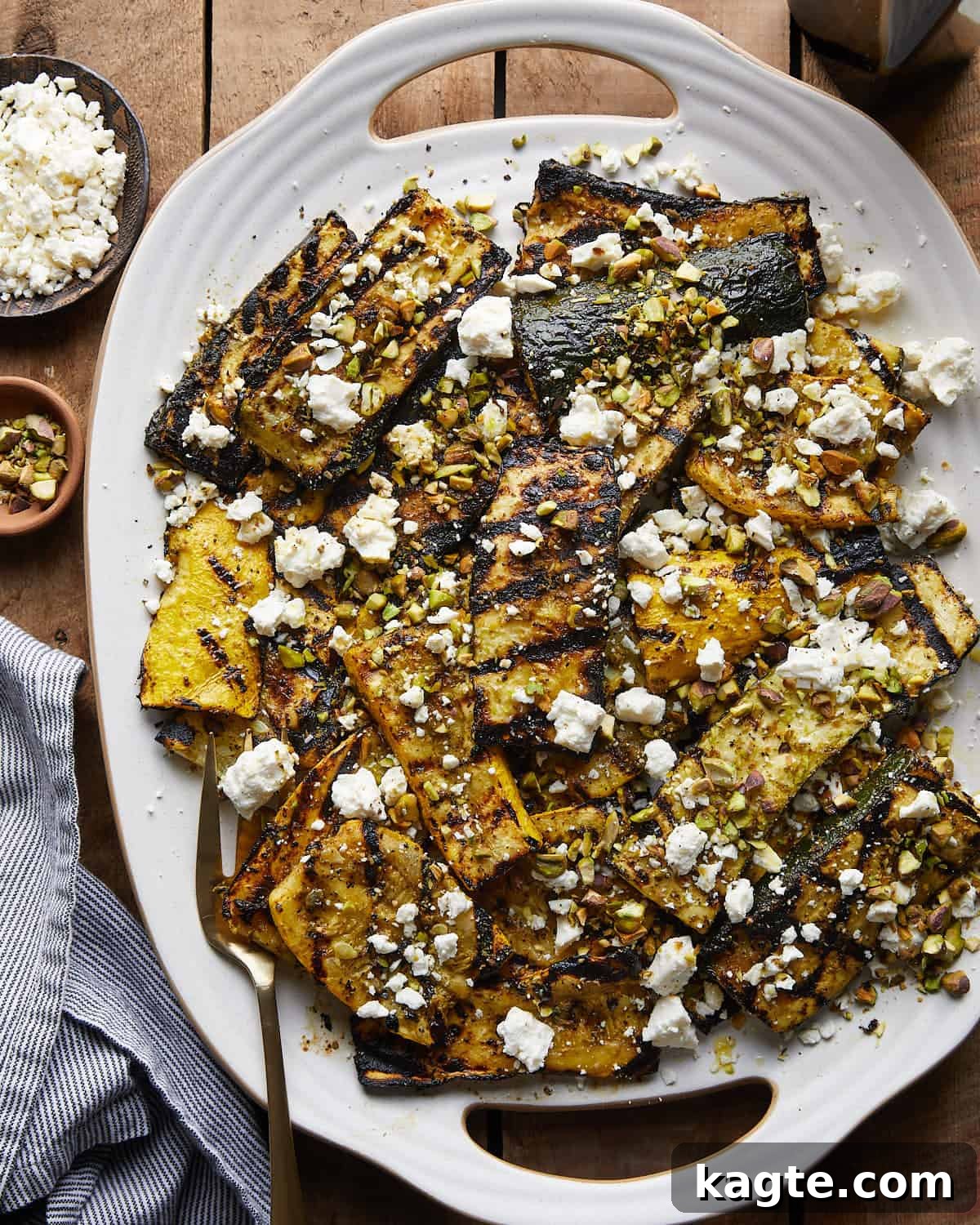 Summer's Grilled Squash Medley 2 Overhead image of perfectly grilled zucchini and yellow squash adorned with crumbled feta cheese and a sprinkle of chopped pistachios, ready to be served.
