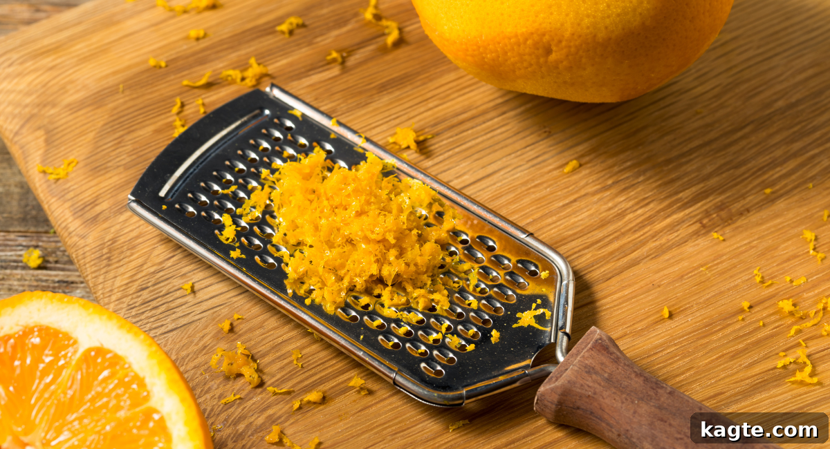 Top 12 Orange Juice Substitutes for Cooking and Baking 13 Overhead image of bright orange zest freshly grated, next to a microplane zester and a whole orange, emphasizing its aromatic quality.