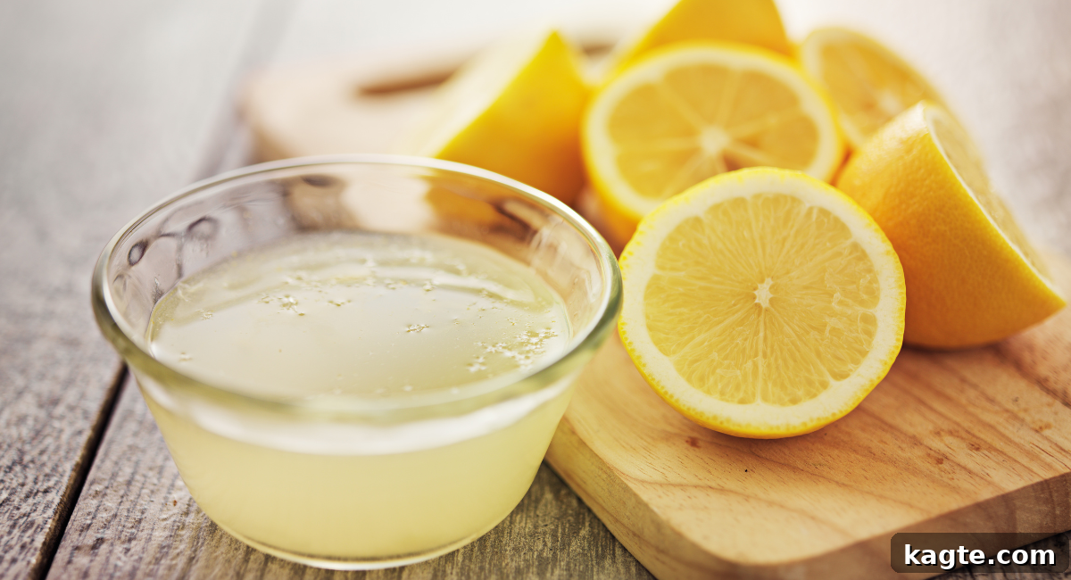 Top 12 Orange Juice Substitutes for Cooking and Baking 3 Close-up image of freshly squeezed lemon juice in a clear glass with bright yellow lemons scattered in the background, conveying freshness and acidity.