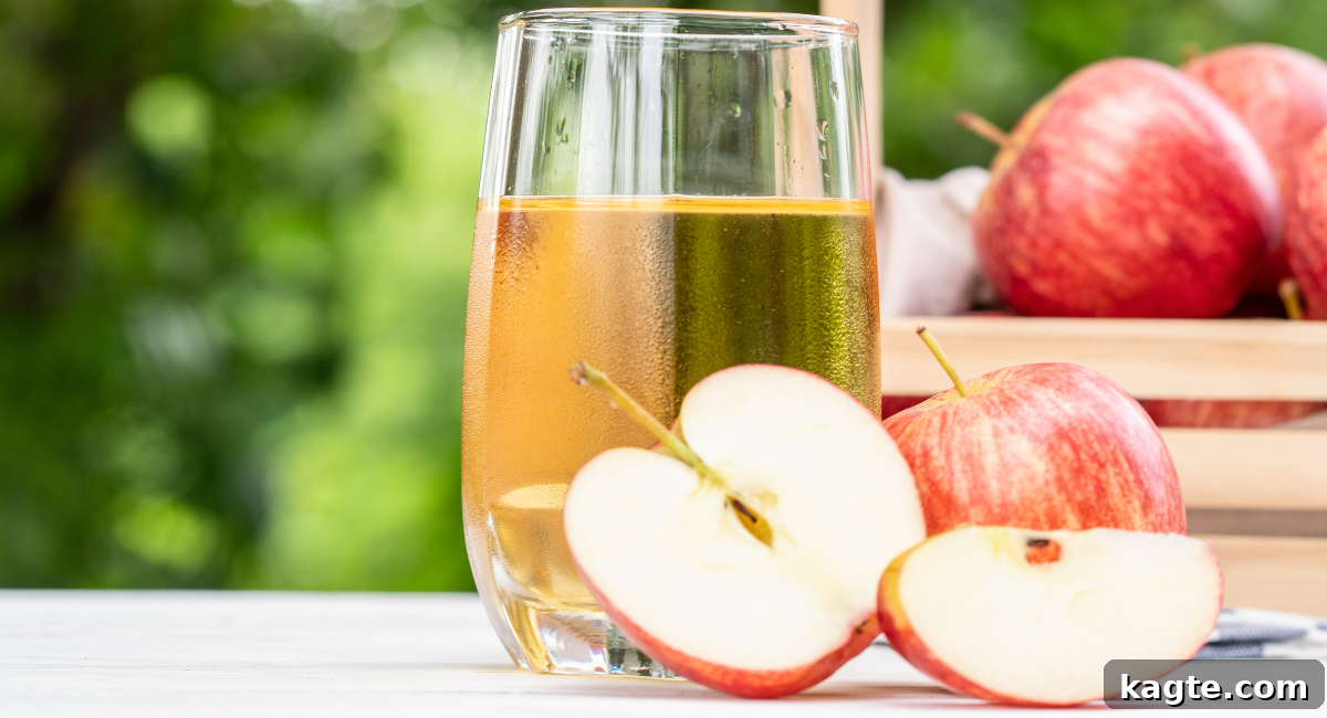 Top 12 Orange Juice Substitutes for Cooking and Baking 6 Close-up image of a glass of clear, crisp apple juice, with fresh red and green apples blurred in the background, suggesting natural goodness.