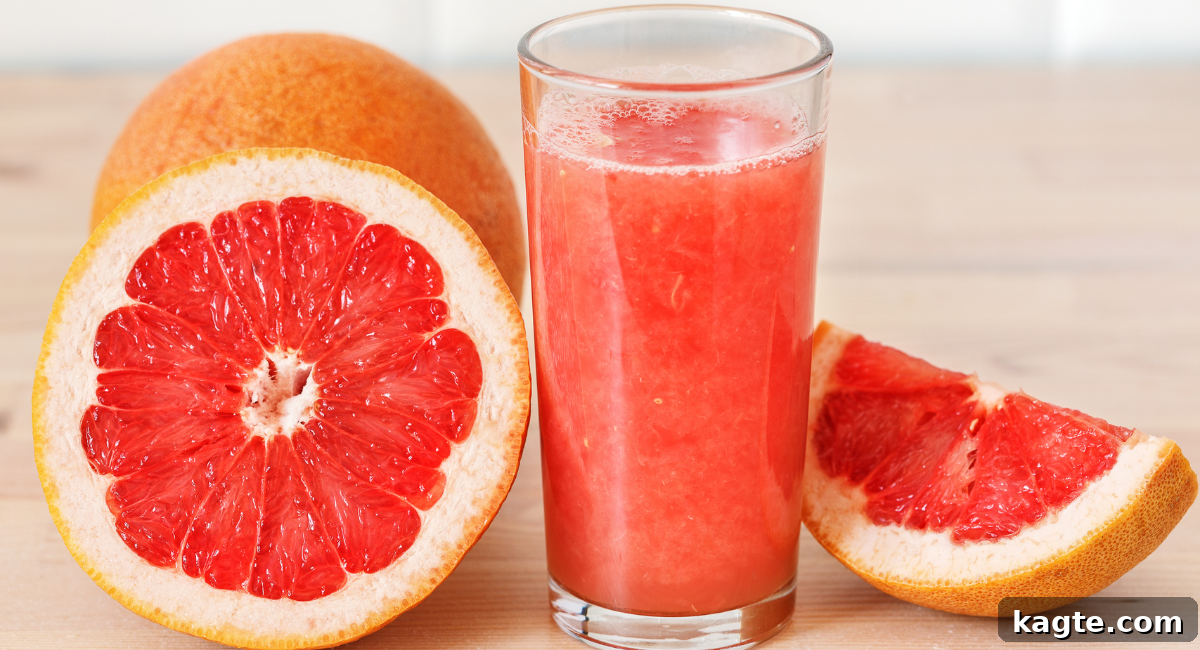 Top 12 Orange Juice Substitutes for Cooking and Baking 7 Close-up image of freshly squeezed grapefruit juice in a glass, with vibrant pink and yellow grapefruits in the background, highlighting its refreshing quality.