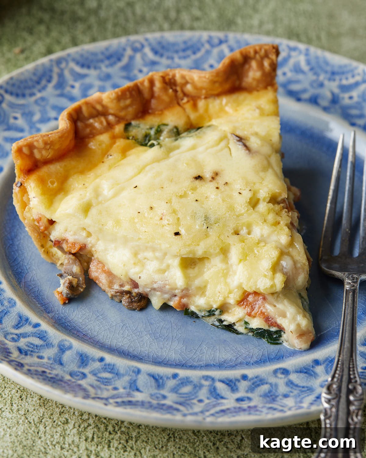 Golden Bacon, Spinach, and Mushroom Quiche with Sharp Cheddar 7 Close-up of a perfectly sliced Bacon Mushroom Spinach Quiche, showing its beautiful layers and creamy texture.