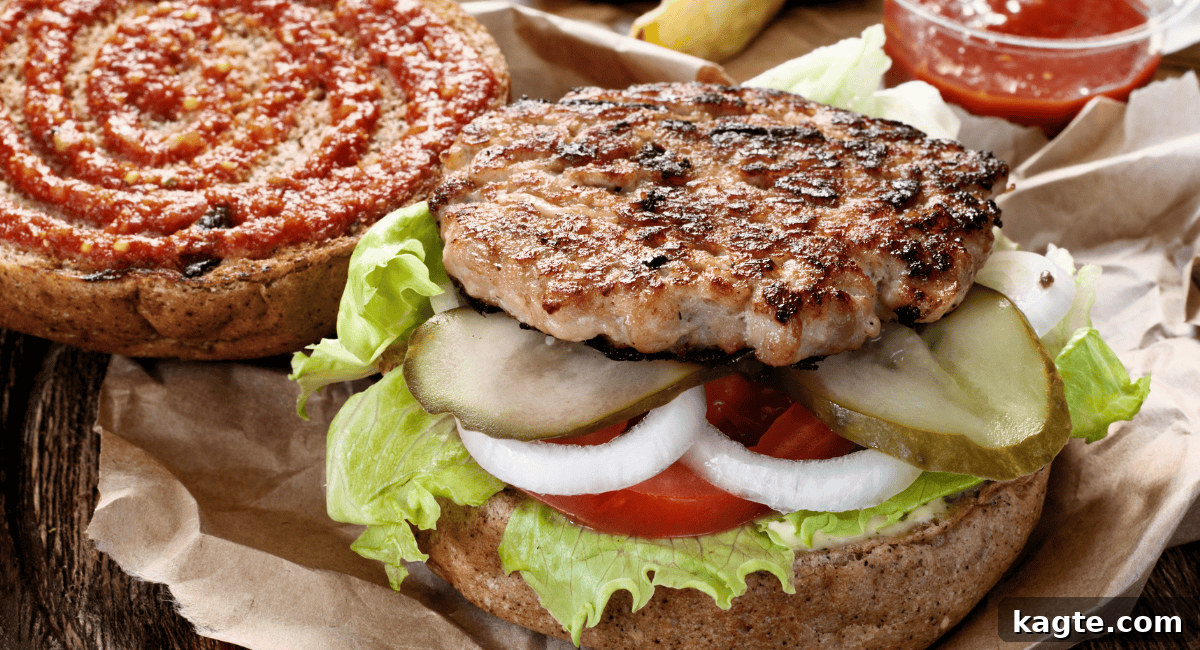 A tantalizing close-up of a perfectly constructed burger, revealing layers of fresh lettuce, vibrant tomato, crisp onions, and tangy pickles beneath a savory patty and melted cheese.