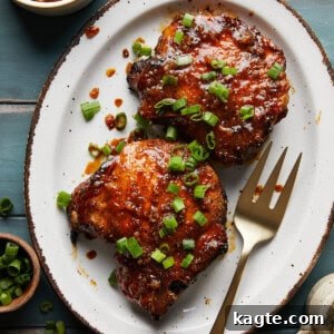A perfectly cooked honey glazed pork chop on a platter, ready to be served, garnished with fresh herbs.