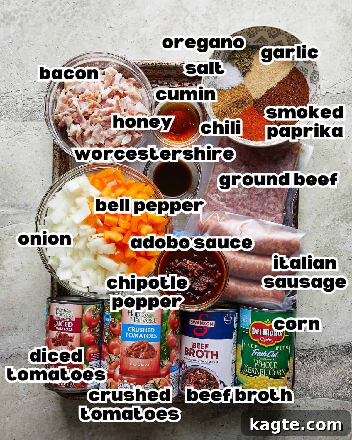 No-Fuss Slow Cooker Beanless Chili 3 Overhead image of all fresh ingredients laid out, including ground beef, diced bacon, onions, bell peppers, canned tomatoes, and spices, required to make slow cooker no bean chili.