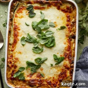 A perfectly baked slice of Veggie Lasagna with Pesto White Sauce, showing golden cheese and distinct layers.