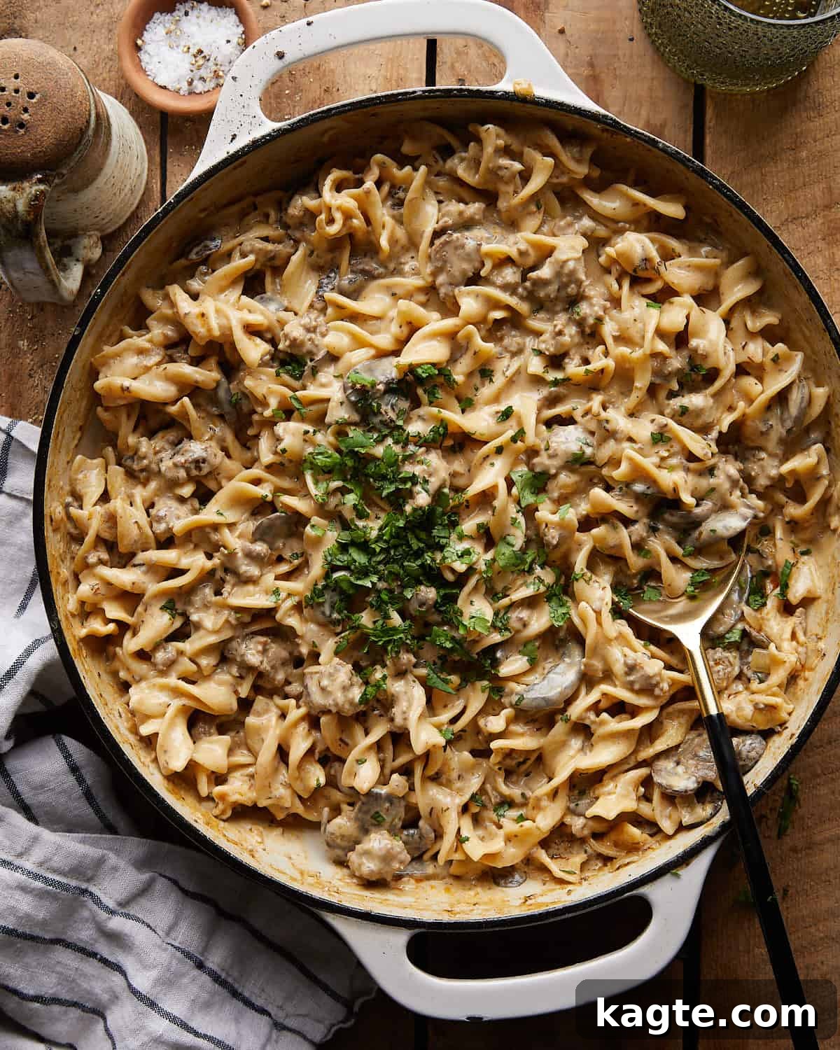 Overhead image of beef stroganoff with ground beef in a white dish with garnish. 