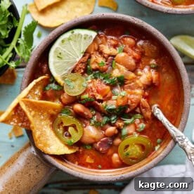 Close-up of hearty Instant Pot Charro Beans, showing bacon, chorizo, and pinto beans.