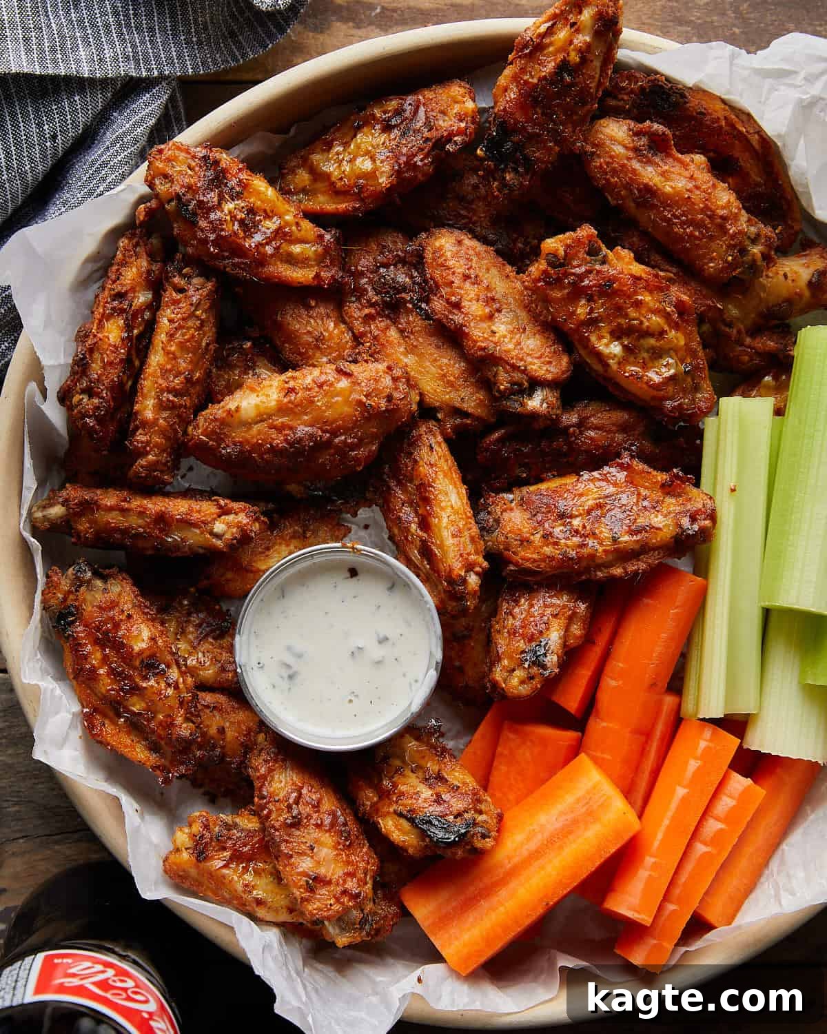 Ultimate Crispy Blackened Wings 2 Overhead image of crispy blackened chicken wings, garnished with fresh celery and carrot sticks, served alongside creamy ranch dressing for dipping.