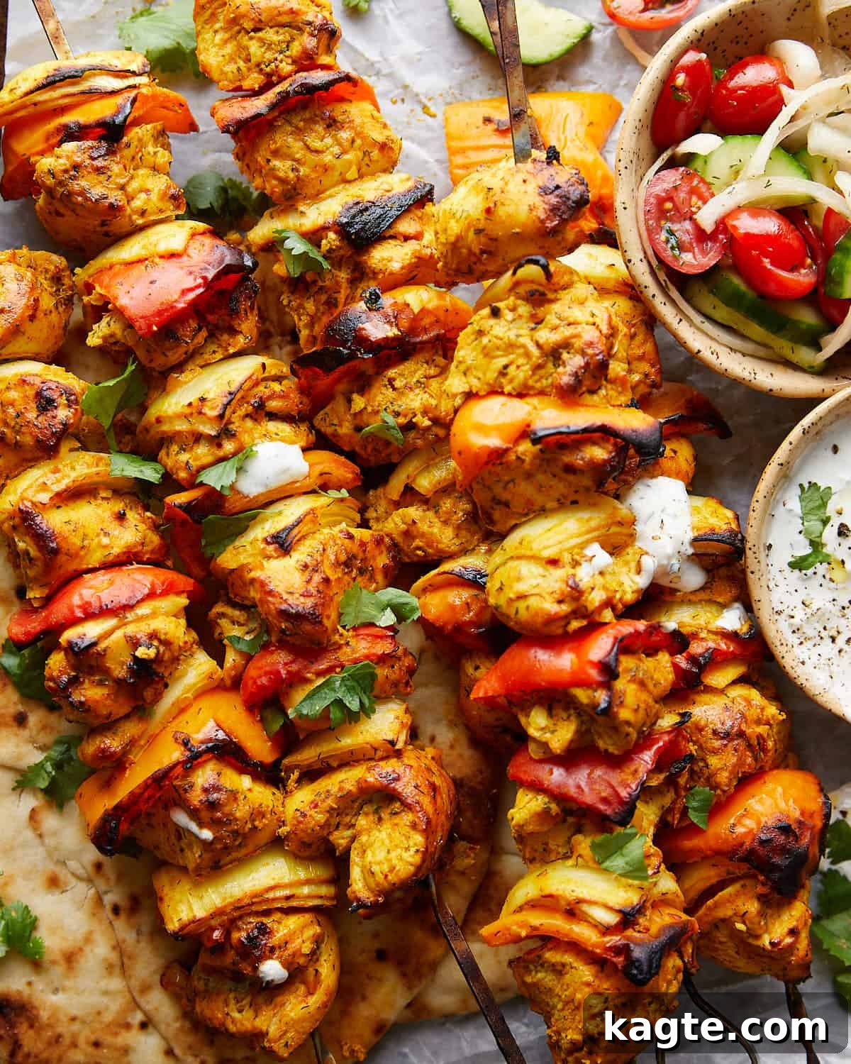 Simple Oven Roasted Chicken Kabobs 5 Up close image of chicken kabobs in the oven, garnished with fresh herbs and a lemon wedge, showcasing their golden-brown char.
