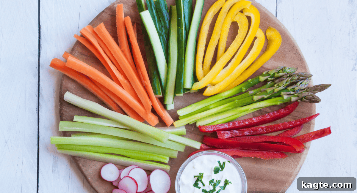 Spinach Dip Versatility Hot or Chilled 3 An overhead shot featuring an artfully arranged platter of colorful, cut vegetables next to a small bowl of creamy spinach dip, highlighting fresh, healthy dipper options.
